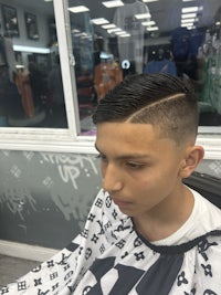 a boy is getting his hair cut in a barber shop